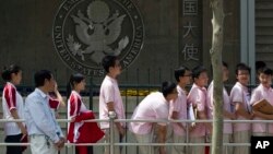 In this May 2012 file photo, Chinese students wait outside the U.S. Embassy for their visa application interviews in Beijing, China. The Open Doors report says the number of international students in the U.S. has increased from 764,000 in 2011 to more than 1 million in 2020.