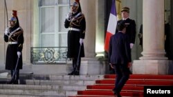 FILE - French President Emmanuel Macron climbs the stairs outside the Elysee Palace in Paris, France, Jan. 23, 2019.
