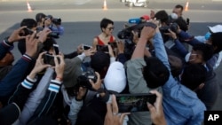 FILE - Theary Seng, rear center, a Cambodian-American lawyer, is surrounding by journalists as she talks to them in front of Phnom Penh Municipal Court, in Phnom Penh, Cambodia, Jan. 14, 2021. 