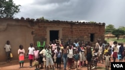 Angola Benguela escola em zona rural con alunos a carregarem as suas proprias cadeiras