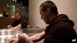 FILE - Richard Chenery injects heroin he bought on the street at the Insite safe injection clinic in Vancouver, B.C., Canada.