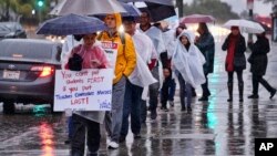 Los Angeles teachers walk on a picket line in pouring rain in front of Los Angeles High School during a city-wide teacher strike on Jan. 14, 2019. 