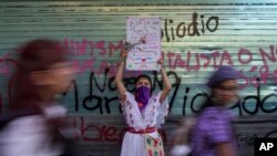 ARCHIVO - Una mujer sostiene un cartel durante la marcha contra la violencia de género, con motivo del Día Internacional de la Mujer, en la Ciudad de México, el miércoles 8 de marzo de 2023.
