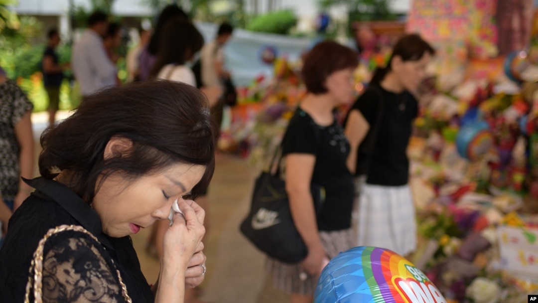 Sarah Kee, 61, of Singapore, wipes her tears at an area set aside for tributes to former Singapore Prime Minister Lee Kuan Yew at the hospital where he passed away, Monday, March 23, 2015 in Singapore. Kee remembers waving to Lee's motorcade daily as it p