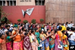 Orang-orang mengantre untuk menukar uang kertas pecahan 2000 rupee India di depan Bank Sentral India sebelum berakhirnya tahun fiskal 2023-24, di Kolkata, India, Selasa, 6 Februari 2024. (Bikas Das/AP)