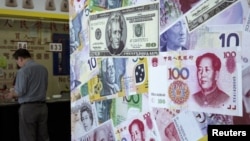 FILE - A customer is served at a counter at a foreign exchange store in Hong Kong, China, Aug. 13, 2015. 