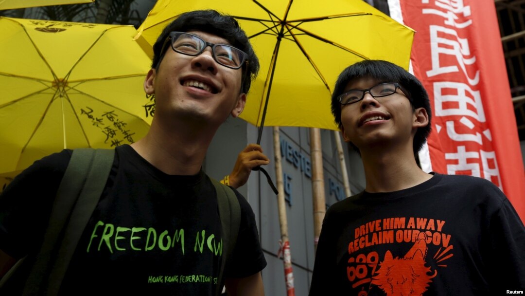 Aktivis mahasiswa Joshua Wong (kanan) dan Nathan Law saat melakukan aksi unjuk rasa "Occupy Central" di luar stasiun polisi Hong Kong (foto: dok).