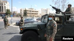 Jordanian army members stand guard outside a hotel that was transformed into a quarantine station amid concerns over the coronavirus (COVID-19) in Amman, March 17, 2020. 