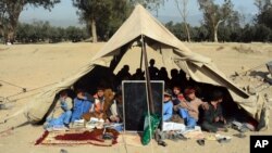 Afghan students attend a school class under a tent in Jalalabad, capital of Nangarhar province, Dec. 16, 2015. According to Afghan Ministry of Education estimates, around 33,000 students have been deprived of education in 58 schools in the Achin, Haskamena, and Kot districts of Nangarhar province.