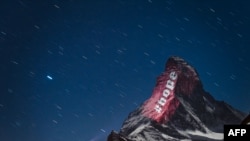 The iconic Matterhorn mountain, located on the Italian-Swiss border that peaks at 4,478 meters, is illuminated by Swiss light artist Gerry Hofstetter "as a sign of hope and solidarity" during the novel coronavirus pandemic, April 1, 2020.