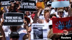 Una manifestante levanta una foto del fiscal general Jeff Sessions mientras cientos de mujeres y activistas de inmigración marchan en una protesta para exigir "el fin de las detenciones familiares" y contra las políticas de inmigración de la administración Trump, en Washington, el 28 de junio de 2018.