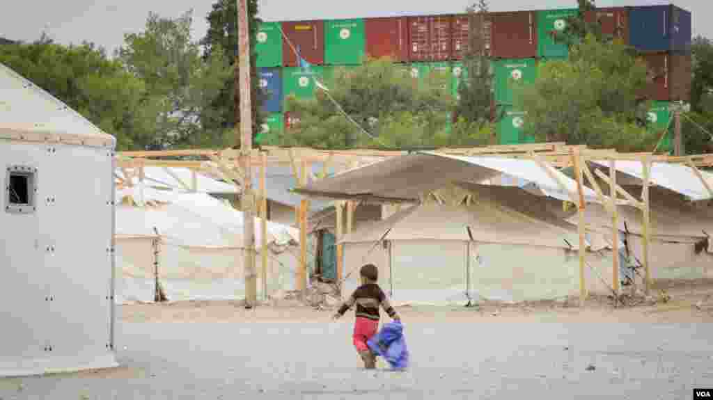 Seorang anak berjalan di kamp Schisto, salah satu dari 50 kamp pengungsi yang tersebar di seluruh Yunani. (VOA/J. Owens)