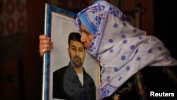 The mother of Palestinian Salah al-Shaer, who has been held by Israel for 20 years, kisses his picture after hearing news on the expected release of her son by Israel, in Khan Younis, in the southern Gaza Strip, Aug. 12, 2013.