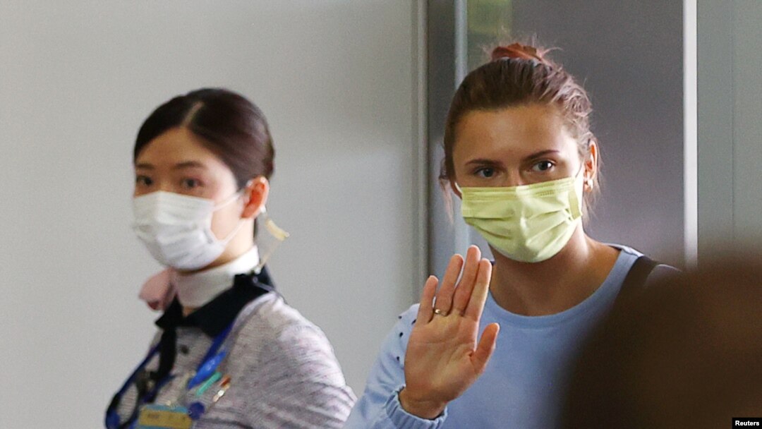 Pelari cepat Belarus, Krystsina Tsimanouskaya, yang berlindung di Kedutaan Besar Polandia di Tokyo, melambaikan tangan sebelum menaiki pesawat untuk terbang ke Wina, di Bandara Internasional Narita, Tokyo, Jepang, Rabu, 4 Agustus 2021. (Foto: Issei Kato/Reuters)