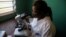 FILE - A laboratory worker uses a microscope at the health center in the commune of Wangata during a vaccination campaign against the outbreak of Ebola, in Mbandaka, Democratic Republic of the Congo, May 23, 2018. 