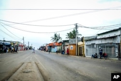 A lone man crosses the empty streets of Maputo, Mozambique, Oct. 21, 2024, during a nationwide shutdown protest following a disputed Oct. 9 election.