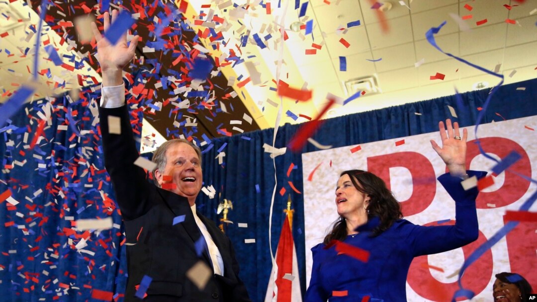 Kandidat Demokrat untuk Senator AS Doug Jones dan istrinya Louise melambai ke pendukung sebelum berbicara pada hari Selasa, 12 Desember 2017 di Birmingham, Alabama.
