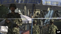 An armed Chinese paramilitary policeman stands guard on a street in Kashgar in China's far western Xinjiang Uygur Autonomous Region, August 4, 2011.