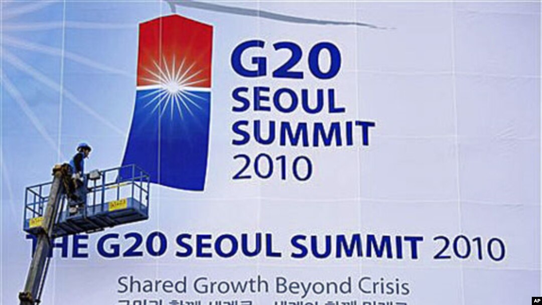 A worker adjusts a giant banner at the entrance to the G-20 Summit in Seoul, South Korea (file photo)