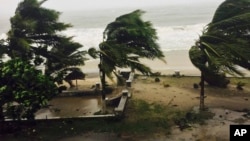 Trees are lashed by strong winds in Sambava, Madagascar, March 7, 2017 as heavy rains and strong winds from a cyclone hit northeast Madagascar, raising concerns about flooding and landslides. 