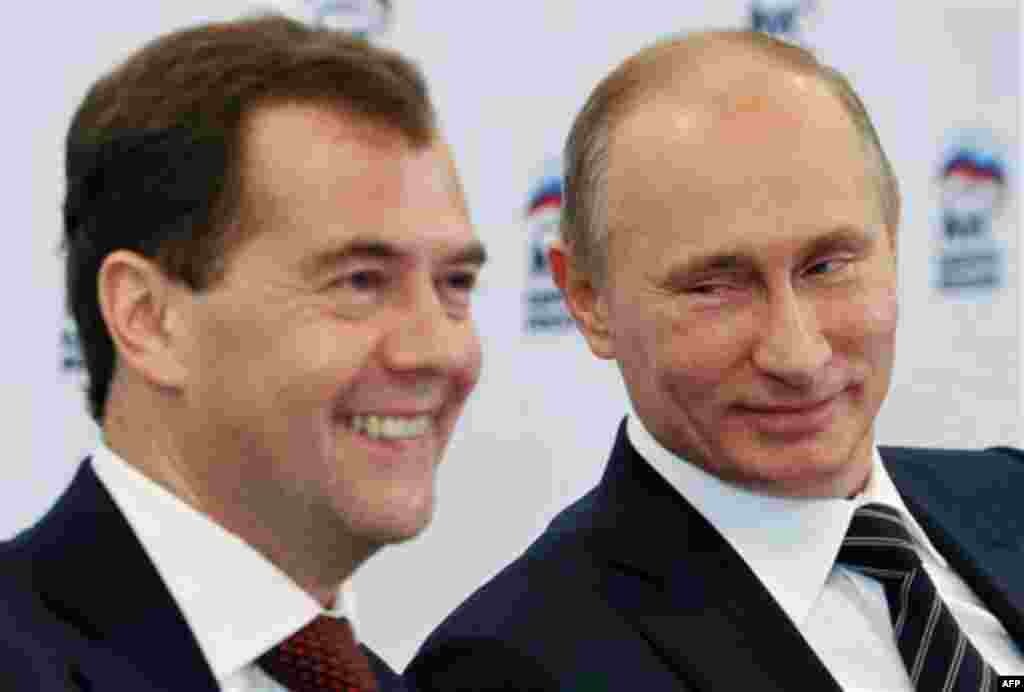 Russian President Dmitry Medvedev, left, and Russian Prime Minister Vladimir Putin participate in a video conference with regional offices of the United Russia party, at the party's headquarters, Moscow, Friday, Oct. 21, 2011. (AP Photo/RIA Novosti, Alexe