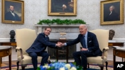 President Joe Biden, right, shakes hands with Israel's President Isaac Herzog during their meeting in the Oval Office of the White House in Washington, Nov. 12, 2024.