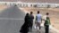 A Syrian refugee family walks towards the new Syrian camp of Azraq, which stretches for 15 kilometers, and lies about 100 kilometers from the Syrian border in Jordan, Wednesday, April 30, 2014.
