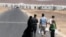 A Syrian refugee family walks towards the new Syrian camp of Azraq, which stretches for 15 kilometers, and lies about 100 kilometers from the Syrian border in Jordan, Wednesday, April 30, 2014.
