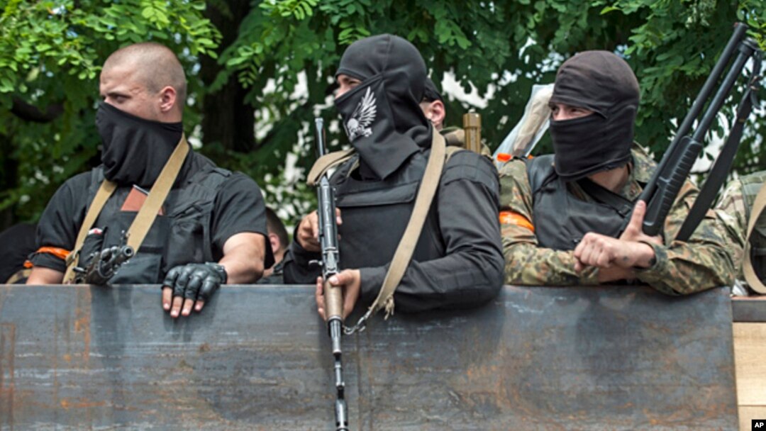 Tentara Ukraina berada di atas kendaraan ketika mereka meninggakan lokasi pertempuran di Mariupol, Ukraine timur, 13/6/2014. 