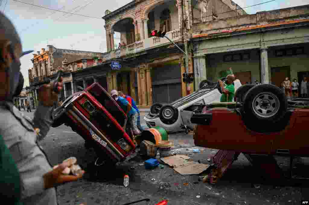 Police cars are seen overturned in the street in the framework of a demonstration against Cuban President Miguel Diaz-Canel in Havana, July 11, 2021. 