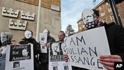 Supporters of WikiLeaks founder Julian Assange, some wearing masks depicting him and holding placards, participate at a demonstration outside the Swedish Embassy in London, Dec 13, 2010