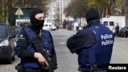 Belgium police officers secure the access during a police operation in Etterbeek, near Brussels, Belgium, April 9, 2016. 