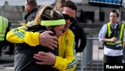 A woman is comforted by a man near a triage tent set up for the Boston Marathon after explosions went off at the 117th Boston Marathon in Boston, Massachusetts April 15, 2013. 