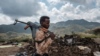 FILE - A member of the Afar Special Forces stands in front of the debris of a house in the outskirts of the village of Bisober, Tigray Region, December 9, 2020.