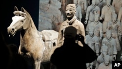 In a Dec. 12, 2017 photo, visitors look over some of the Terracotta Army soldiers on exhibit at the Virginia Museum of Fine Arts in Richmond, Va. 