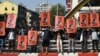 FILE - Demonstrators hold up placards depicting deposed Myanmar leader Aung San Suu Kyi during a protest against the Feb. 1, 2021, military coup in the country, in Yangon, Myanmar, Feb. 17, 2021. 