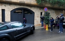 Journalists are seen near a car entering the garage of a house believed to belong to former Nissan chairman Carlos Ghosn in Beirut, Lebanon, Jan. 2, 2020.