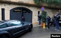Journalists are seen near a car entering the garage of a house believed to belong to former Nissan chairman Carlos Ghosn in Beirut, Lebanon, Jan. 2, 2020.
