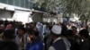 Afghans queue in long lines in front of Kabul Bank hoping to withdraw money, in Kabul, Afghanistan, Aug. 15, 2021. 