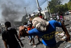FILE - Protesters march on the street to demand the resignation of President Jovenel Moise in Port-au-Prince, Haiti, Oct. 11, 2019.