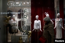 Seorang pembeli berjalan melewati iklan penjualan Black Friday yang dipajang di jendela toko di Pentagon City, Arlington, Virginia, AS, 27 November 2024. (Benoit Tessier/REUTERS)