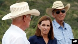 La candidata al senado de EE.UU. Martha McSally, republicana de Arizona, durante una visita a la frontera con México se reúne con los ganaderos Jim Chilton (izquierda) y Tom Kay (derecha) el 22 de agosto de 2018.