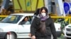 A woman wearing a protective mask crosses a street in Iran's capital Tehran, Feb. 22, 2020.