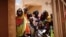 FILE - Local women and children arrive at an abandoned clinic to receive medical care from the French military during Operation Barkhane in Ndaki, Mali, July 29, 2019. 