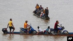 Venezolanos cruzan el río Arauca, la frontera natural entre Venezuela y Colombia, para refugiarse en Arauquita, Colombia, el 26 de marzo de 2021.