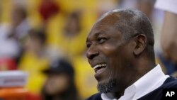 FILE - Hakeem Olajuwon, a former college athlete from Nigeria and a Houston Rockets player, smiles before Game 6 of the NBA basketball Western Conference Finals in Oakland, Calif., May 26, 2018.