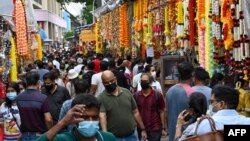 People make their way on a street to buy goods and decorative ornaments on the eve of the Hindu festival of Diwali in the Little India district in Singapore on November 3, 2021. (Photo by Roslan RAHMAN / AFP)