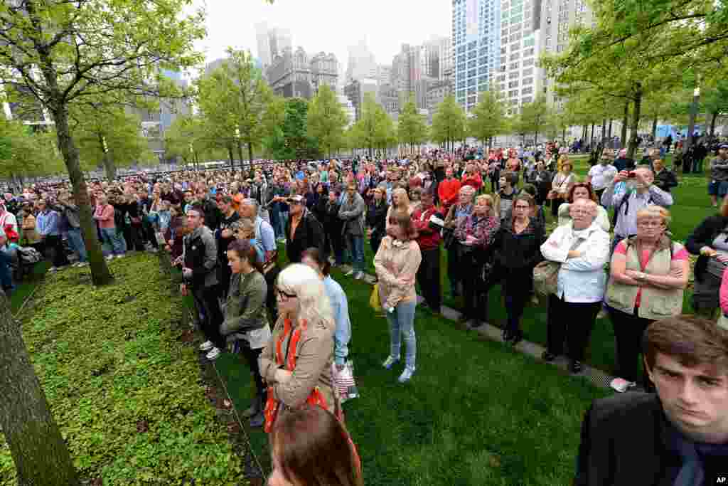 Members of the public watch a projection screen at the World Trade Center Plaza during the dedication ceremony of the National September 11 Memorial Museum, New York City, May 15, 2014.