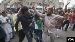 Warga pendukung partai politik relijius Sunni berdansa dengan iringan lagu nasional Pakistan dalam demonstrasi anti-Amerika di Karachi (28/9).