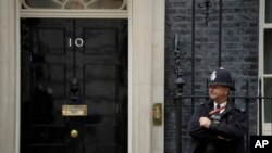 A police officer stands guard outside the door of 10 Downing Street in London, June 7, 2019. 